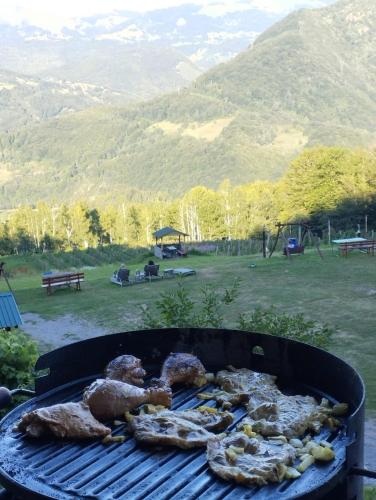 a bunch of meat cooking on a grill at Kolibe Ćorić in Mojkovac