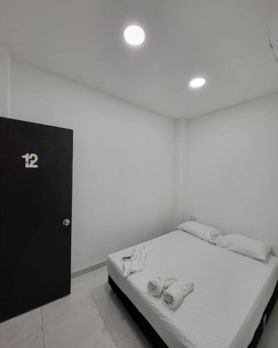 a bed in a room with a white wall at Hostal Casa Familiar Josi in Tolú