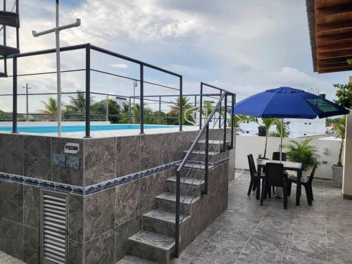 a patio with a table and a blue umbrella at Hostal Casa Familiar Josi in Tolú