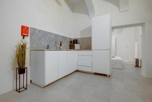 a kitchen with white cabinets and a counter top at Comfy 1 Bedroom in the Heart of Valletta in Valletta