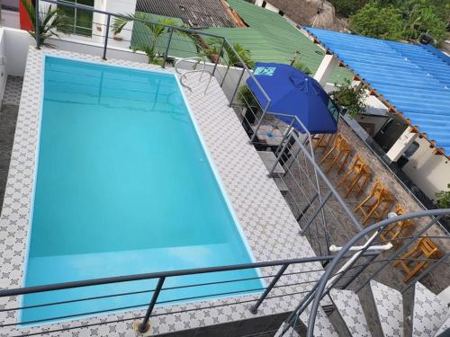 an overhead view of a blue swimming pool with an umbrella at Hostal Casa Familiar Josi in Tolú