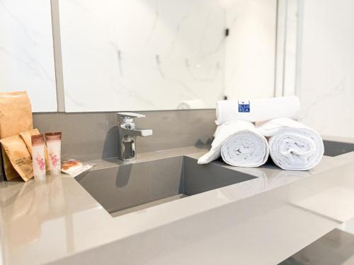 a kitchen counter with a sink and towels at Blue Sea Hotel in Itapema