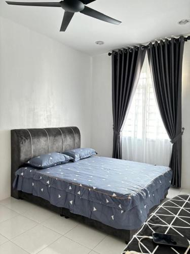 ein Schlafzimmer mit einem Bett mit Deckenventilator in der Unterkunft KH Homestay 2 Seri Manjung in Seri Manjung