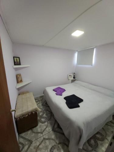 une chambre avec un lit avec des objets violets dessus dans l'établissement Cabaña Vivir, à El Chalten