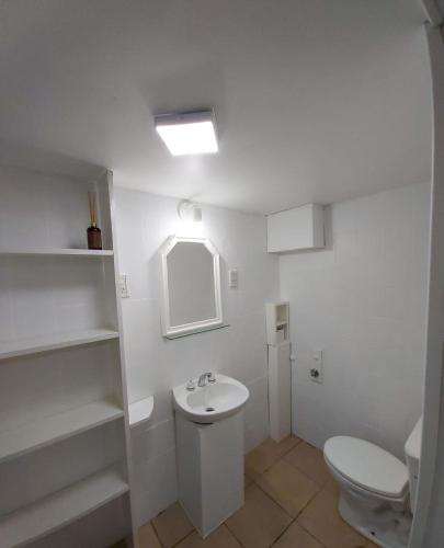 une salle de bains blanche avec toilettes et lavabo dans l'établissement Cabaña Vivir, à El Chalten