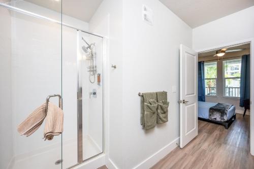 Gated Resort Style 2BR - KING Bed, Pool Views, SPA Hot Tub, Gym, WiFi, Wash & Dry, AC, Elevators, Starbucks, EV CHRG Station, Free Parking, Pets -- IDEAL FOR Medical, Business, Relocation, Long Stays - by Moffitt Cancer Ctr, USF, River Hills Country Club في تامبا: حمام مع السير في الدش بجوار باب زجاجي