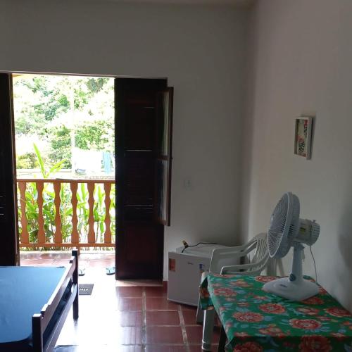 a room with a room with a table and a fan at Ubatuba's Surf hotel in Ubatuba
