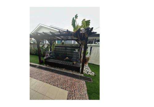 a pergola in the backyard of a house at Nurasyura Puncak Guesthouse in Seri Iskandar