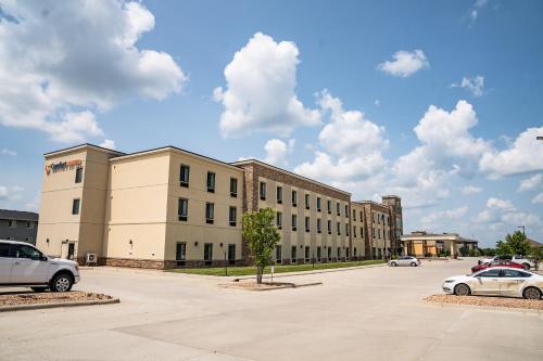 a large building with cars parked in a parking lot at Comfort Suites University Brookings in Brookings