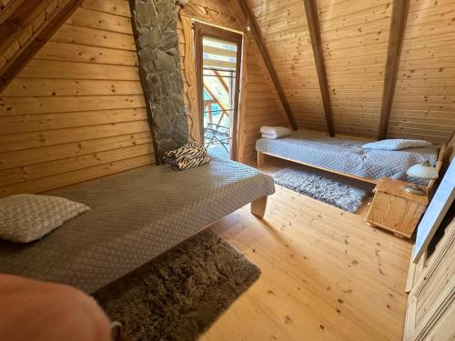 a room with two beds in a wooden cabin at Domki w górach '' Zielone Wzgórza '' okolice Karpacza in Karpacz