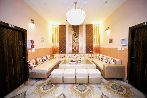 a living room with couches and a chandelier at The Orchid Retreat in Agra