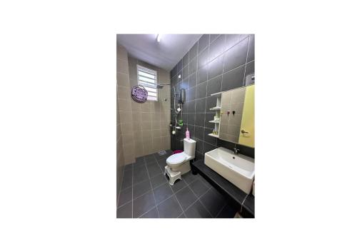 a bathroom with a toilet and a sink at Nurasyura Puncak Guesthouse in Seri Iskandar