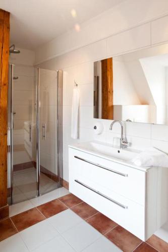a white bathroom with a sink and a shower at Möckelsnäs Herrgård in Diö