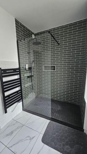 une douche avec une porte vitrée dans une salle de bain dans l'établissement Appartement T2 lumineux, à Brest