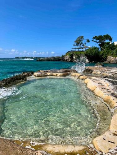 a hot spring in the ocean with a waterfall at Seaside 2 Bedroom Oasis at 7 Miles Beach, Negril, Point Village in Negril