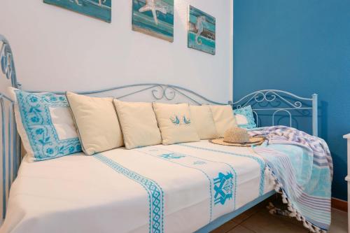 a blue bedroom with a bed with a hat on it at Il Piccolo Giardino rooms & breakfast in Villasimius