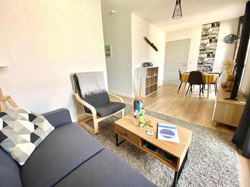 un salon avec un canapé bleu et une table dans l'établissement Le Maréchal, spacieux avec place de parking, à Limoges