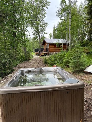 a hot tub in the middle of a yard with a cabin at Rocky Mountain Cabins and Home in Golden