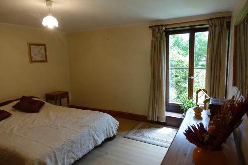 a bedroom with a bed and a large window at La Fazenda in Combourg