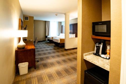 a hotel room with a room with two beds and a television at Comfort Suites University Brookings in Brookings
