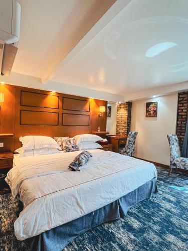 a hotel room with a large bed and two chairs at Muzdan Holiday homes in Unayzah