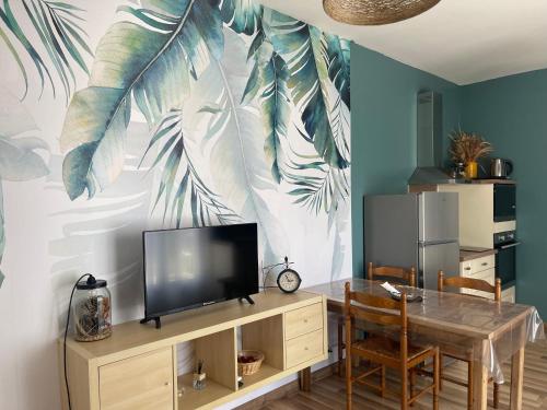 Il comprend un salon avec une télévision et une table à manger. dans l'établissement Gite d'Alexandra, à Saint-Germain-et-Mons