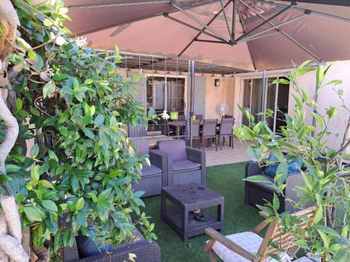a patio with plants and chairs and an umbrella at Chez J-JM in Marseille
