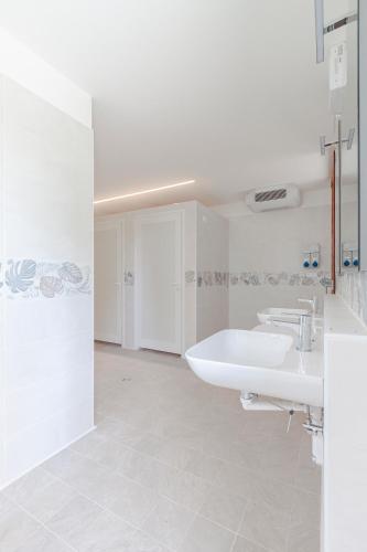 a white bathroom with two sinks and a tub at AgriCamping Ca' Bodi in Cavallino-Treporti