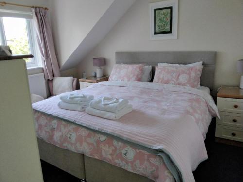 a bedroom with a bed with two towels on it at Summat Else B & B in New Quay