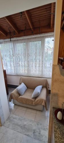 a bedroom with a couch in front of windows at stratigato in Chios