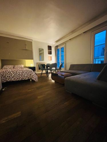 une chambre avec un lit, un canapé et une table dans l'établissement La maison du bonheur à Charonne, à Paris