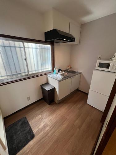 a small kitchen with a sink and a microwave at 关西机场难波梅田直达花園町の夢旅人 in Osaka