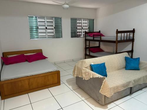 a bedroom with two beds and a couch in it at Studio Cotia Centro próximo ao Animalia Park CT do São Paulo Thermas da Mata Shopping Central Park in Cotia