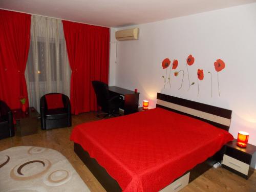 Un dormitorio con una cama roja con adornos de amapola en la pared en Studio Lujerului Bucuresti, en Bucarest