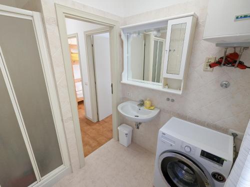 a bathroom with a washing machine and a sink at Il granchio in Marcelli
