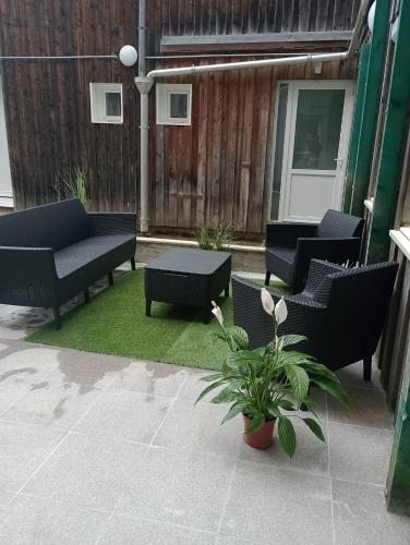 a patio with couches and a table and plants at Les Cèdres in Morbier