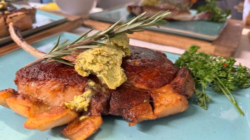 a piece of meat on a blue plate with herbs at Landgasthof Ochsen in Sinzheim