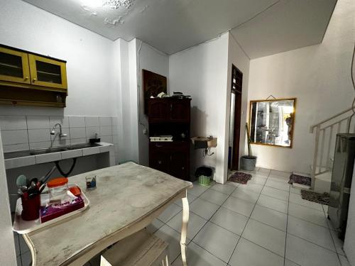 a kitchen with a table and a sink at AKKA Sharia Guesthouse in Srondolwetan