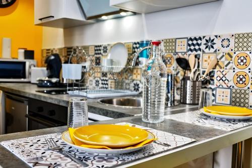 - un comptoir de cuisine avec des plaques jaunes et un évier dans l'établissement T2 Chic proche de la gare Châteaucreux, à Saint-Étienne