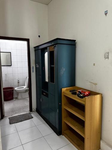 a bathroom with a blue cabinet and a toilet at AKKA Sharia Guesthouse in Srondolwetan