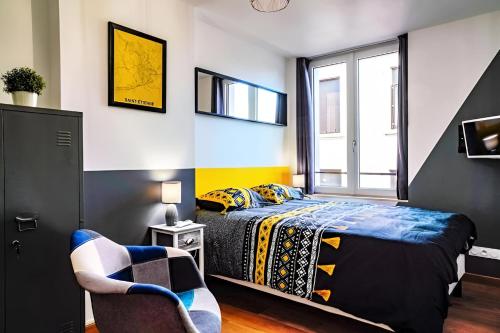 une chambre avec un lit et une chaise dans l'établissement T2 Chic proche de la gare Châteaucreux, à Saint-Étienne