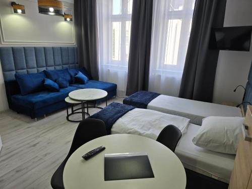 a hotel room with two beds and a couch at Eldom-NOCLEGI, Kolejowa 15 Wągrowiec in Wągrowiec