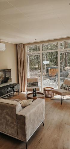 a living room with two couches and a piano at Elly's Broekhuisje in Haarle