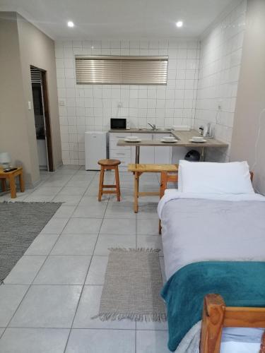 a room with two beds and a kitchen at Darize Self Catering Flat in Kimberley