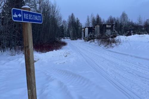 a blue street sign on the side of a snow covered road at Hebergement du grenier 2 0 in Notre-Dame-des-Monts