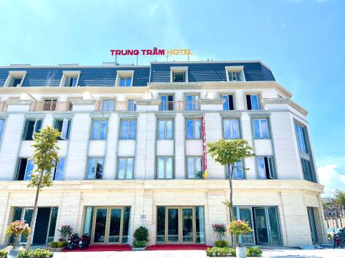 a white building with a sign on it at Khách sạn Trung Trầm in Dong Hoi