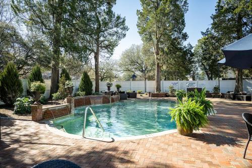 una piscina en un patio con árboles en The Willcox, en Aiken