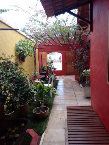 a garden with potted plants and a red building at CASA DA RE Suite 2 in Jericoacoara