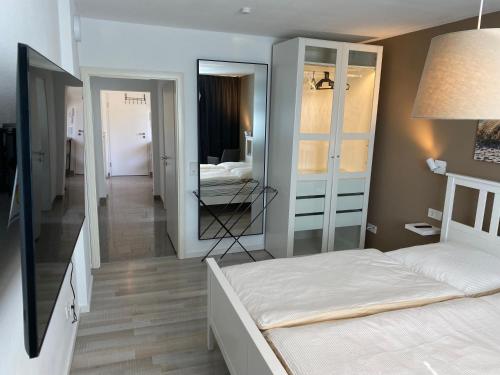 a bedroom with a bed and a mirror at All-In Apartments in Fischeln mit Gartenblick, nähe Düsseldorf - Messe - Airport - HELIOS in Krefeld
