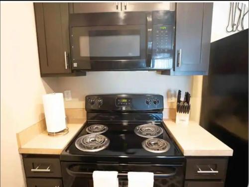 a kitchen with a stove and a microwave at Cozy King 2 bedroom at Easton near Airport in Columbus